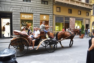 Florence, Italy. September 17, 2023. A carriage carrying tourists in an upscale shopping street in