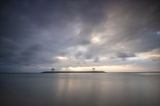 Beautiful seascape in the morning. Tropical sandy beach with breakwater and reflection of the sky