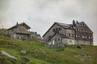 Wooden building of a mountain farm on a green hill, Alps, Austria, Europe