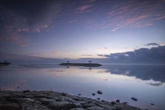 Beautiful seascape in the morning. Tropical sandy beach with breakwater and reflection of the sky