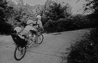 Germany, Berlin, 27.06.1991, Tandem bicycle with two children and one adult, (three of them) in