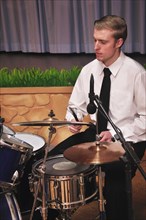 Detail of a man playing drums in a live performance