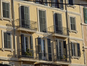 Multi-storey building with numerous balconies and shutters, illuminated by sunlight, palma de