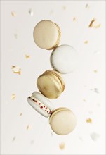 White, yellow, gold macaron cookies. Colorful, sweet small French macaroon cakes. Light beige