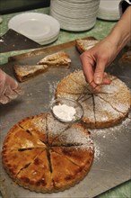 Cook sprinkling icing sugar on delicious homemade apple pies