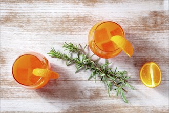 Orange cocktails with rosemary, overhead flat lay shot on a wooden background, Food photography