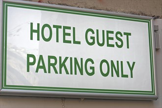 Hotel guest parking only reserved sign board at wall