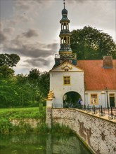 Castle with tower, moat and bridge, cloudy sky, dornum, east frisia, germany