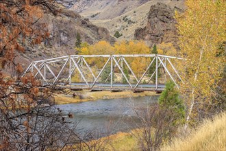 A steel bridge spans the Bitterroot river in western Montana during Autumn