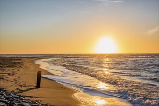 Den Helder, Netherlands. January 2022. Setting sun on the beach of Den Helder, Netherlands.