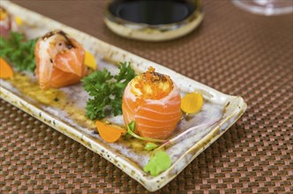 Platter decorated with different flavors of elegant sushi. Selective focus