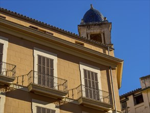 Historic building with balconies and a tower under a clear blue sky, palma de Majorca, mallorca,