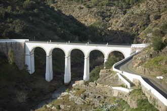 Mertola beautiful white and stone bridge on the city entrance with almond trees on the landscape in