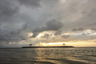 Beautiful seascape in the morning. Tropical sandy beach with breakwater and reflection of the sky