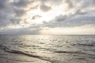 Beautiful seascape in the morning. Tropical sandy beach with breakwater and reflection of the sky