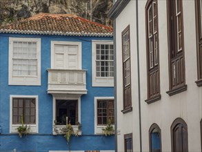 Blue-painted building with white windows and tiled roof in an old neighbourhood, la palma, canary