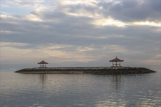Beautiful seascape in the morning. Tropical sandy beach with breakwater and reflection of the sky