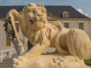 Lion statue with coat of arms in close-up in front of a historic building, dornum, east frisia,