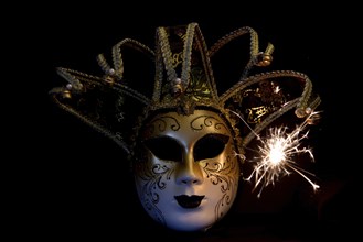 Den Helder, the Netherlands. December 2022. Venetian carnaval mask on black background with sparks.