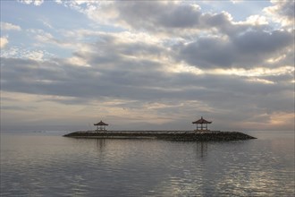 Beautiful seascape in the morning. Tropical sandy beach with breakwater and reflection of the sky