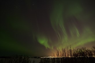 Northern lights and Reykjavik lights from Heidmork, Iceland, Europe