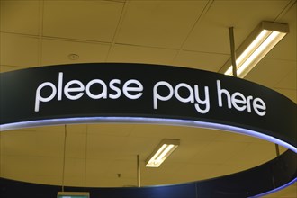 Signage in a large department store directs customers to the checkout