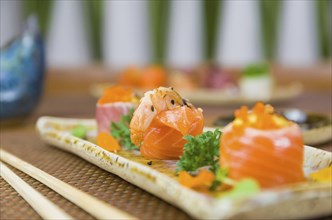 Platter decorated with different flavors of elegant sushi. Selective focus