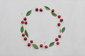 Gray concrete flat lay with big sweet cherries on table background. Top view on huge, massive