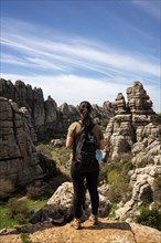 Woman looking at limestone rock formations in El Torcal de Antequera nature reserve, in Spain