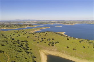 Dam lake reservoir drone aerial view of Barragem do Caia Dam olive trees landscape in Alentejo,