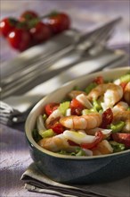 Shrimp salad with squid tomatoes celery inside an oval bowl