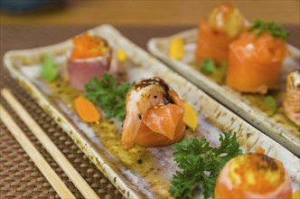 Platter decorated with different flavors of elegant sushi. Selective focus