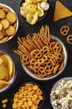 Salty snacks, party mix, shot from the top. An assortment of appetizers. Crackers, popcorn etc,