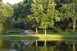 An antique car is parked by a pond near Warsaw, Indiana