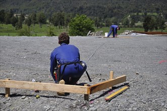 Builders mark out the profile for a building at a construction site in Westland, New Zealand,