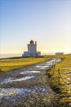 Trail leading to the famous lighthouse at sunset on Dyrholaey beach in Iceland in the cold winter,