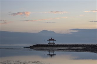 Beautiful seascape in the morning. Tropical sandy beach with breakwater and reflection of the sky