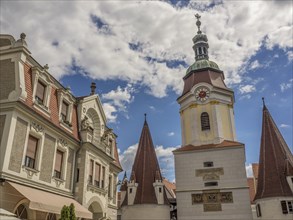 Historic buildings with church tower and spires, under a blue sky with clouds, Dürnstein, Wachau,