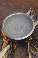 Boiling water in pot over camp fire