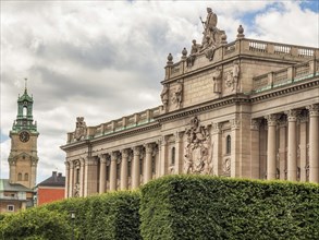 Majestic historical building with decorations and statues on a slightly cloudy sky background,