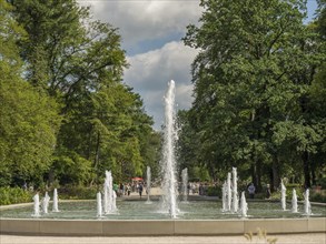 High rising water jet of a fountain in a green park on a sunny day, Bad Lippspringe, Germany,