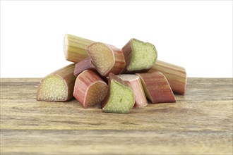 Variety of rhubarb stalks of varying colors from pale green to deep red on wooden cutting board