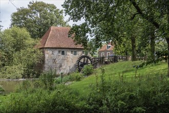 Historic mill with a wooden wheel, surrounded by nature and green trees, Eibergen, Gelderland, the