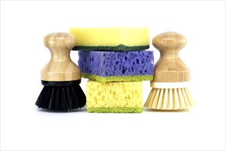 Three sponges, each a different color purple, yellow, and blue and two brushes with wooden handles