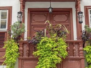 Red balcony with lush plants on a wooden façade of historic buildings, la palma, canary islands,