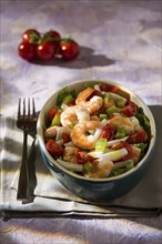 Salad of shrimps with squid tomatoes celery inside an oval bowl