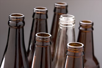 A close up of several brown glass bottles and one clear glass bottle