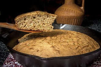 A slice of zucchini bread served from a cast iron skillet