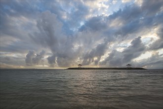 Beautiful seascape in the morning. Tropical sandy beach with breakwater and reflection of the sky
