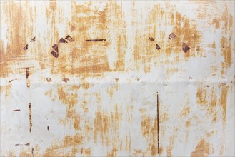 White sheet metal wall with rust and flaking paint